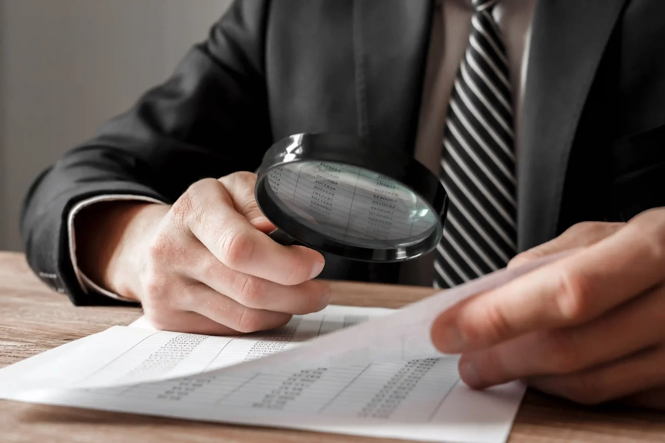 businessman-holding-magnifying-glass-zoom-analyzing-financial-indicators_11zon