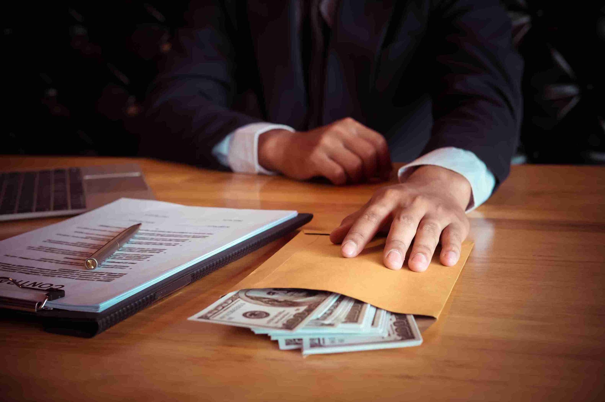 man holding scaled money and documents