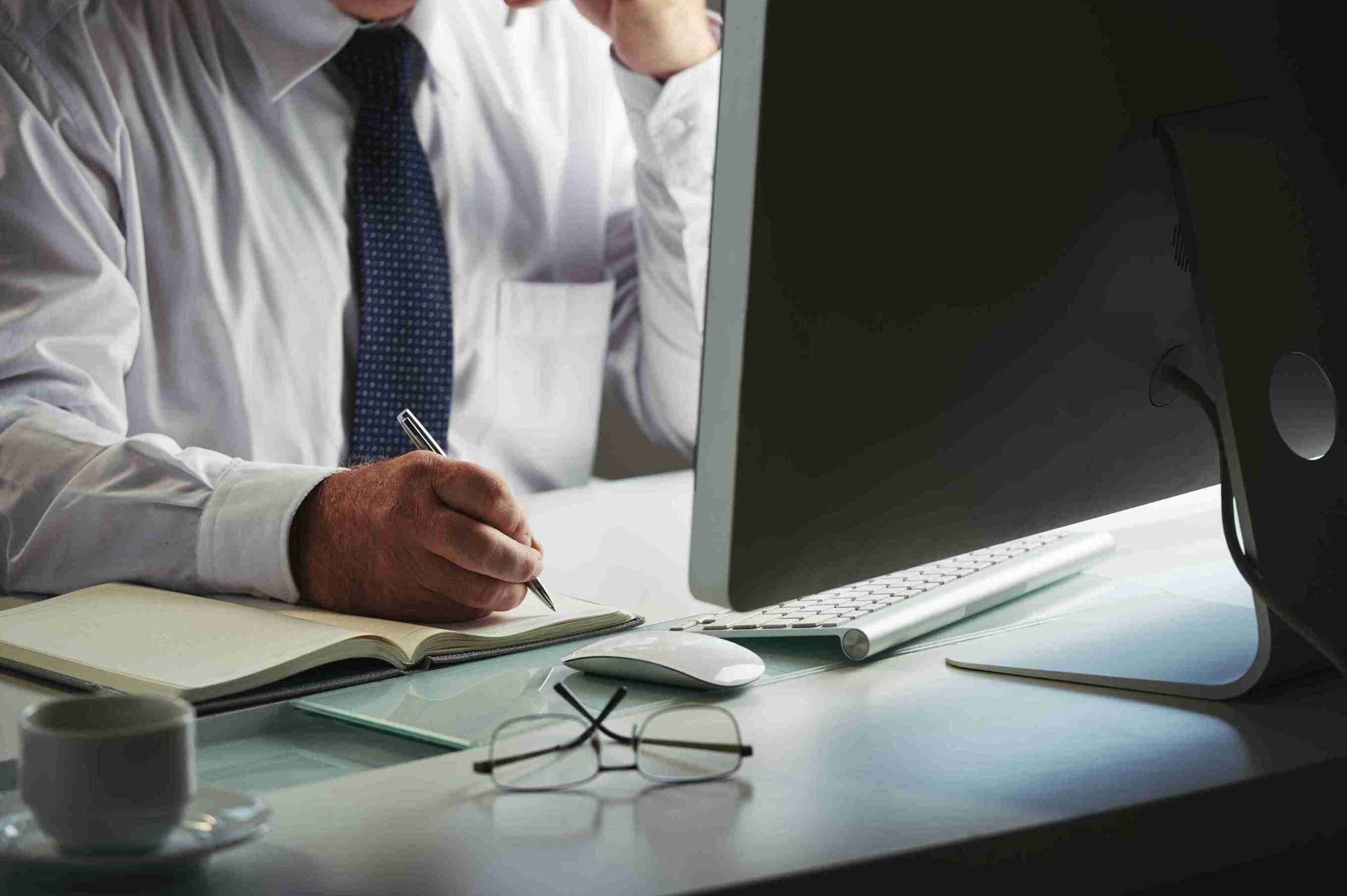 mid-section-unrecognizable-man-formalwear-making-notes-workplace-computer_11zon